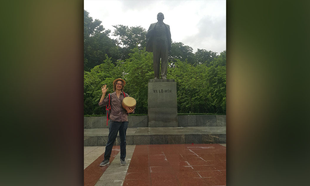 Борис Слободчиков с барабаном на фоне статуи Ленина в Ханое, Вьетнам
